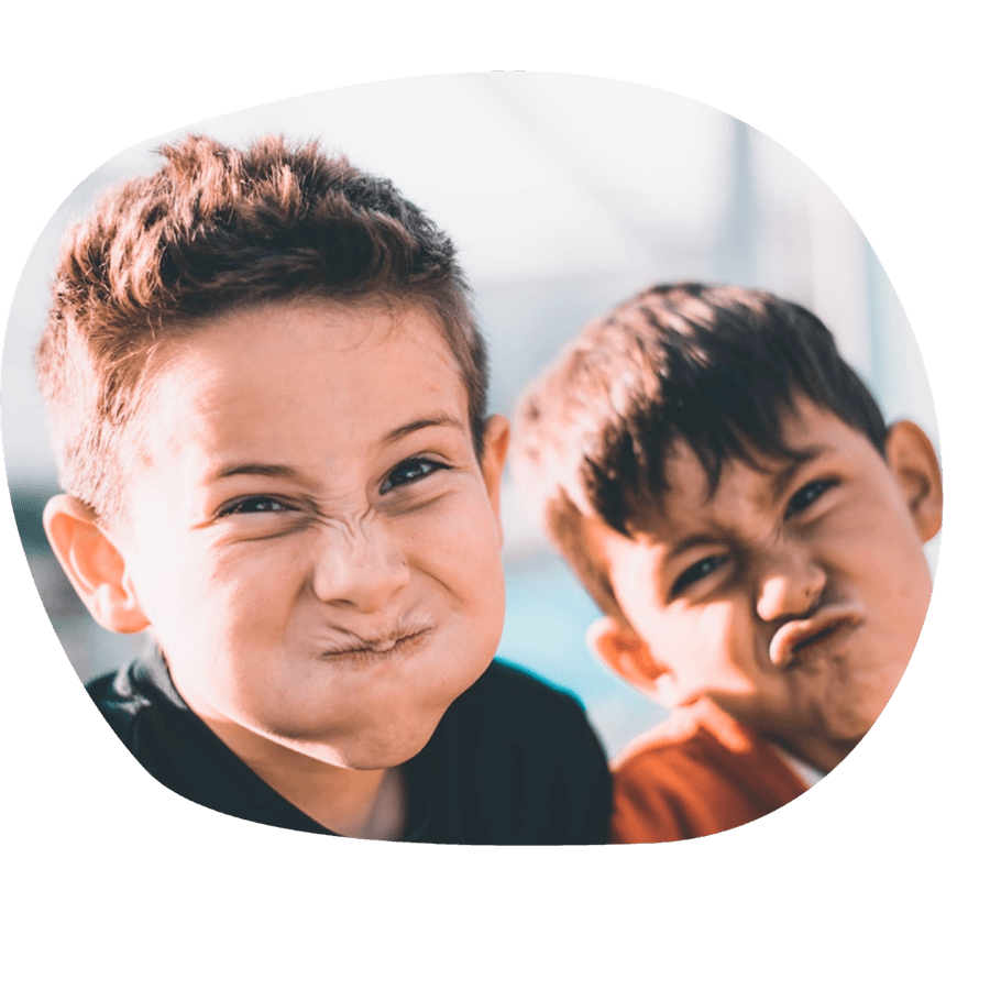 Due bambini che fanno smorfie buffe e divertenti, durante un momento di gioco del corso estivo Move Your Summer