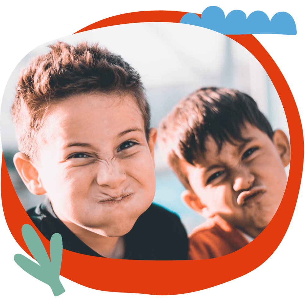 Attività 6 Due bambini che fanno smorfie buffe e divertenti, durante un momento di gioco del corso estivo Move Your Summer