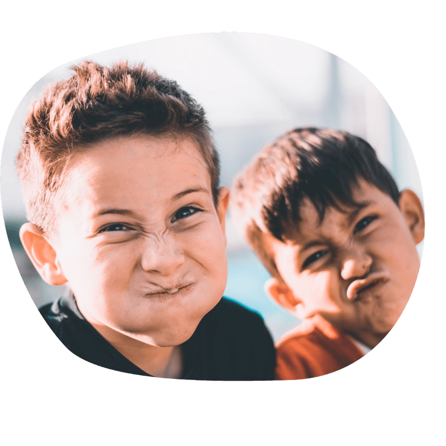 Due bambini che fanno smorfie buffe e divertenti, durante un momento di gioco del corso estivo Move Your Summer